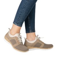 Baskets légères beiges avec panneaux en maille et accents en liège. Présentent des semelles grises et blanches, des lacets élastiques et un col rembourré.