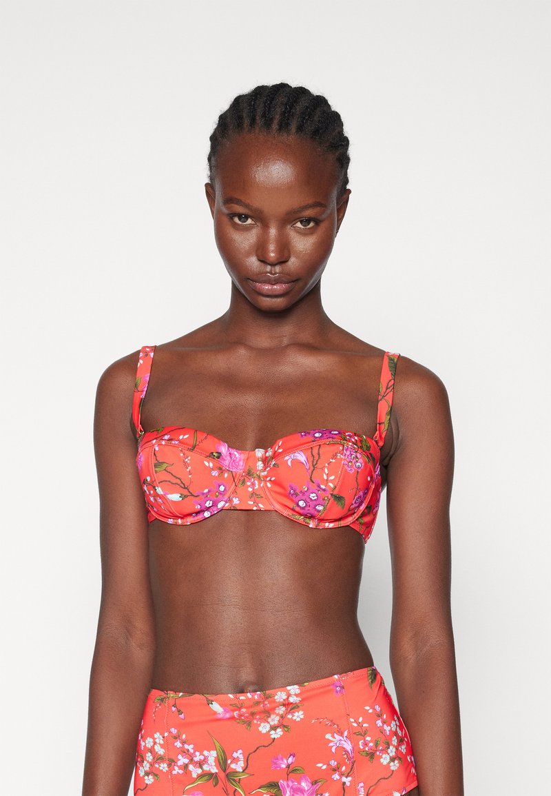 Red floral bikini top with underwire and adjustable straps, featuring multicolored flower patterns and a smooth texture.