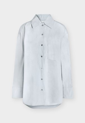 Chemise à manches longues bleu clair avec boutons, col pointu et une poche poitrine avant, présentée sur un fond uni.