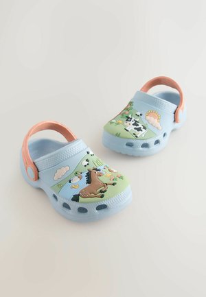 Blå och gröna barnträskor med djurmotiv, med en häst, ko och anka. Tillverkade av lätt material, med en rosa rem.