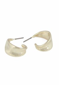 Ett par blanka, böjda, guldtonade hoops örhängen med metalldelar på en vit bakgrund, som visar både framsidan och inre detaljer.