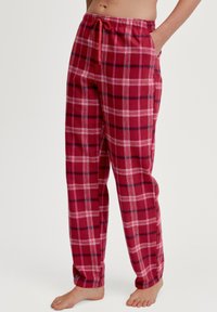 Rode geruite pyjamabroek van zacht materiaal, met een tailleband met trekkoord en zijzakken. Het patroon bevat witte en blauwe lijnen.