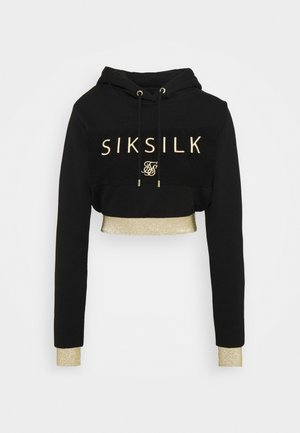 Zwarte cropped hoodie met gouden "SIKSILK" tekst op de voorkant, gouden trekkoorden aan de uiteinden, en gouden glinsterende manchetten en tailleband.