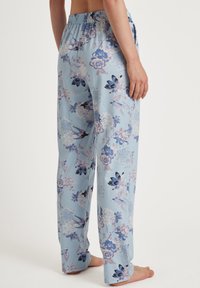 Lichtblauwe bloemen pyjamabroek met een elastische tailleband. Beschikt over verschillende bloemenpatronen in tinten paars, blauw en roze.