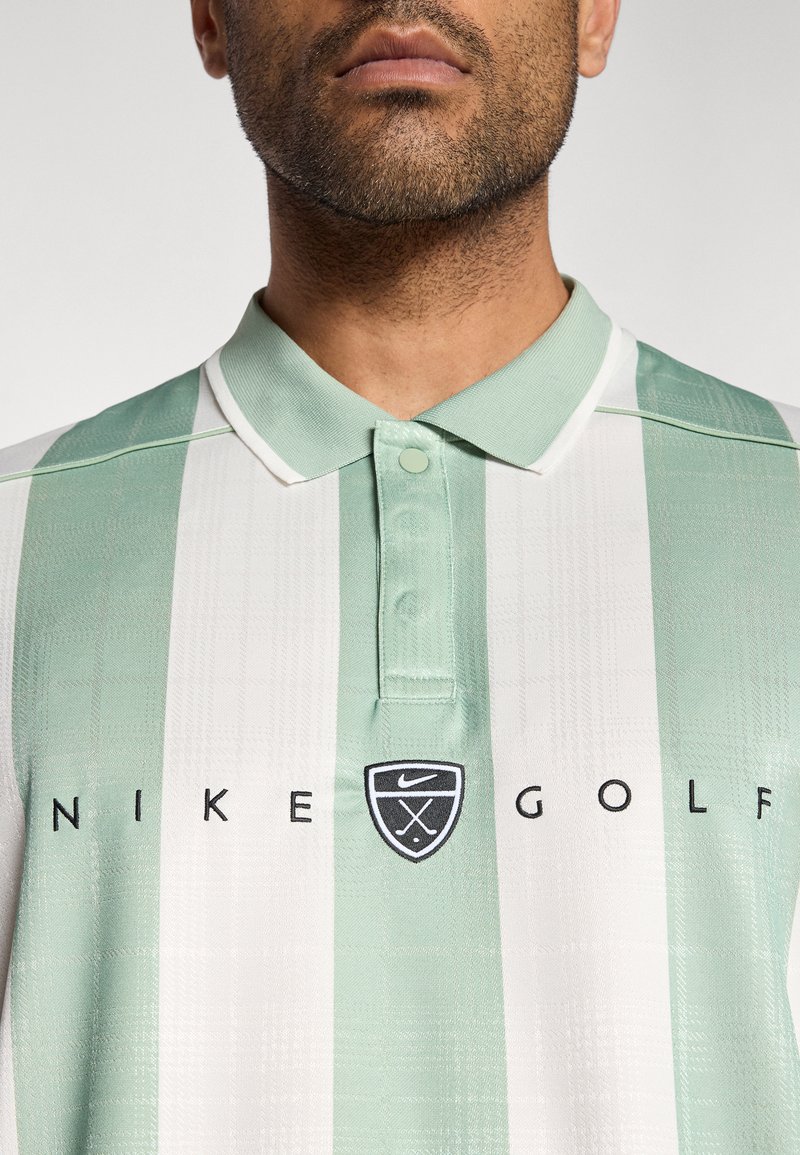 Polo à rayures vert clair et blanc, avec un col à boutons, le logo Nike Golf, et un tissu texturé.