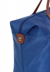 Borsa in nylon blu con forma strutturata, dotata di chiusura superiore con zip e dettagli in pelle marrone con cuciture visibili e un particolare metallico a scatto.