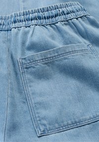 Light blue denim shorts featuring an elastic waistband, a single patch pocket, and visible stitching details. Soft texture and casual design.