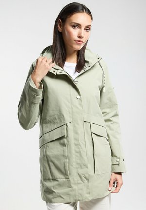 Veste imperméable vert clair avec capuche, fermeture à boutons à l'avant, deux grandes poches avant et cordon de serrage réglable. Texture lisse.