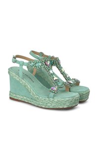 Sandali con zeppa verde menta con accenti di gioielli e suola espadrille testurizzata. Presentano cinturini alla caviglia e una finitura in suede morbido.