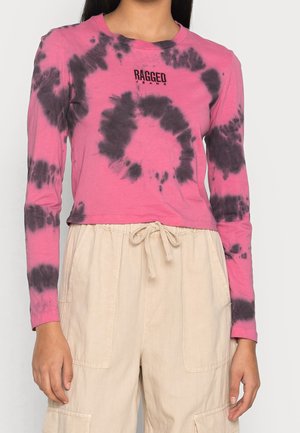Long-sleeve pink tie-dye shirt featuring black swirl patterns, crew neck, and "RAGGED" logo at the chest, paired with beige drawstring pants.