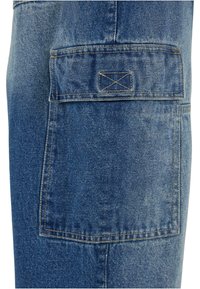 Denim cargo pants in medium blue. Features a large patch pocket with topstitching detail, slightly faded texture, and straight-leg design.