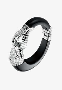 Pulsera bangle negra con textura pulida, presenta acentos de tono plateado con escamas y garras detalladas, incluye un mecanismo de cierre.