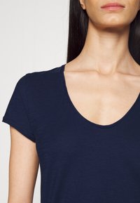 Navyblaues T-Shirt mit kurzen Ärmeln, Rundhalsausschnitt, aus weichem, strukturiertem Stoff. Verfügt über eine lockere Passform und glatte Nähte.