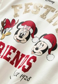 Fehér póló, hímzett karakterekkel: Mickey, Minnie és egy kakas Mikulás sapkában, arany flitteres "ÜNNEPI BARÁTOK" felirattal.