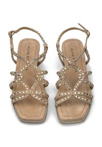 Beige suède sandalen met meerdere kruislings gespen, versierd met strass-steentjes. Vierkante neusontwerp en enkelband met verstelbare gesp.