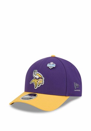 Purple and yellow Minnesota Vikings cap with NFL Draft 2023 badge and New Era logo on white background.
