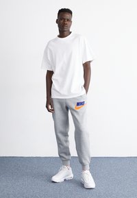 Nike Sportswear JOGGER - Träningsbyxor - dark grey heather