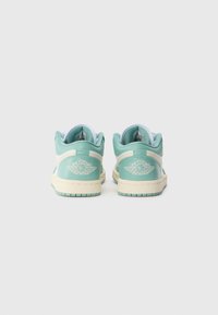 Grønn og kremfarget lær sneakers med lavt design, som har polstret krage, brodert logo og strukturert gummisåle.