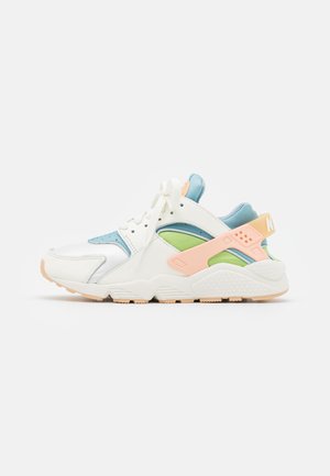 Hvid og pastel sneaker med en blanding af læder og mesh; har blå, grønne og pink accenter, en tekstureret sål og snørelukning.