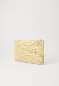 Beige vävd påse gjord av texturerat material, med dragkedjestängning och rektangulär form för kompakt förvaring.