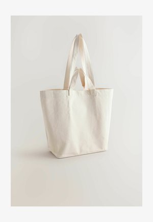Plátěná taška v off-white farbe, vybavená dvoma pevným uchami a obdĺžnikovým tvarom. Povrch je hladký, bez viditeľných vzorov či kovových prvkov.