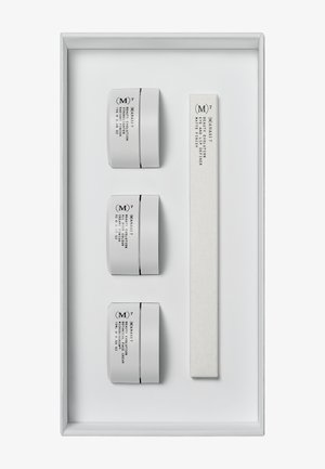 Tre hvide beholdere med sort tekst mærket "MAN 57" og en rektangulær hvid spartel i en hvid bakke. Rent, minimalistisk design.