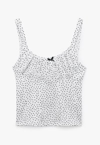 Hvid tanktop med sorte prikker, der har tynde stropper og en samlet frontdetalje. Buet kant med en lille sort sløjfe som accent.