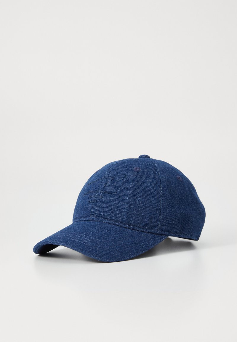 Marineblaue Kappe aus Denim, mit runder Krone, gebogenem Schirm und dezentem Logo-Stick auf der Vorderseite.