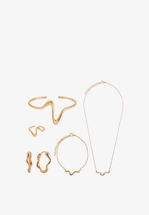 Set aus sechs goldfarbenen Schmuckstücken mit wellenförmigen, abstrakten Designs, darunter Manschettenarmband, Ring, Ohrringe, Kettenarmband und Halskette.