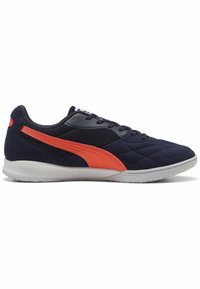 Zapatillas deportivas en navy con acentos naranjas. Parte superior de tejido con textura de rombos acolchados. Cierre de cordones ajustado, suela de goma para tracción.