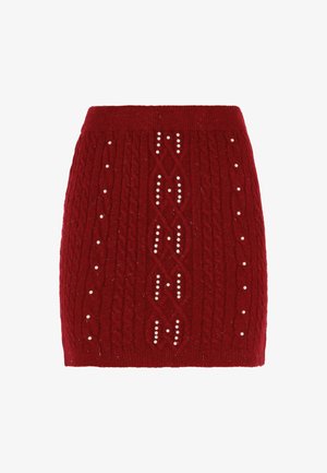 Rode gebreide rok met kabelpatronen en decoratieve witte kralen. Strak ontwerp met een geribbelde tailleband. Zachte textuur.