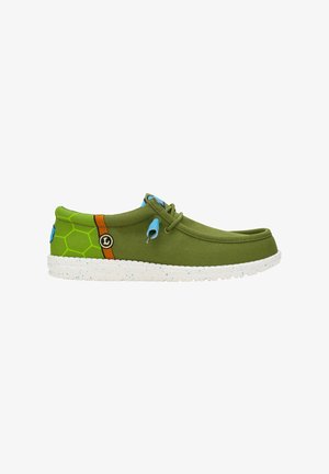 Grüne Segeltuchschuhe mit runder Zehenpartie, die ein Wabenmuster in Grün und braunen Akzenten aufweisen, einer blauen Öse und einer weiß gesprenkelten Sohle.