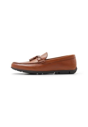 Mocasín de cuero marrón con punta redondeada, costuras tonales, herrajes decorativos y suela de goma negra. Acabado suave con acentos mínimos.