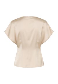 Blouse beige à manches courtes, en satin, silhouette ajustée, col rond, fermeture éclair au dos. Texture lisse, éclat subtil.