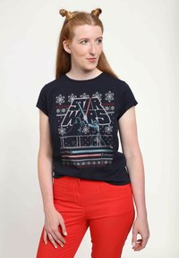 Mörkblå t-shirt med en Star Wars-grafik och snöiga mönster. Designen inkluderar röda och blå ljussablar mot en mörk bakgrund.