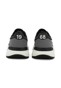Scarpe sportive grigie e nere con i numeri bianchi "19" e "68" sui talloni. Presentano una suola bianca imbottita e dettagli neri testurizzati.
