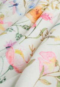 Lillelille lilledega kangas, millel on pehme valge taust ja värvikad prindid roosa, oranži ja siniste lilledega, mis on põimunud roheliste lehtedega.