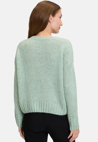 Ljusgrön stickad tröja med avslappnad passform, ribbat nederkant och långa ärmar. Mjuk textur, något lös väv och casual design.