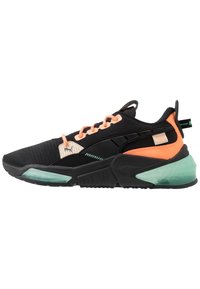 Scarpa da ginnastica nera e arancione neon con dettagli verde menta, suola testurizzata e lacci pesca, mostrata di profilo laterale.