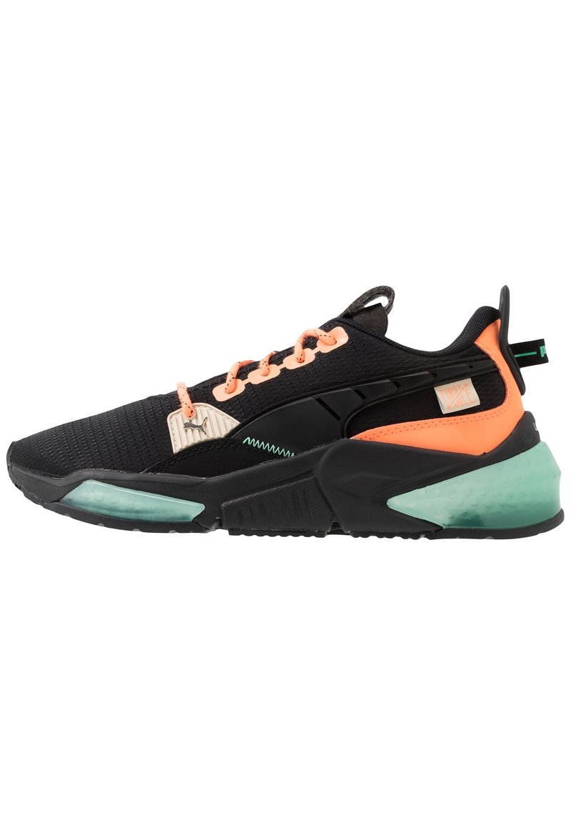 Scarpa da ginnastica nera e arancione neon con dettagli verde menta, suola testurizzata e lacci pesca, mostrata di profilo laterale.