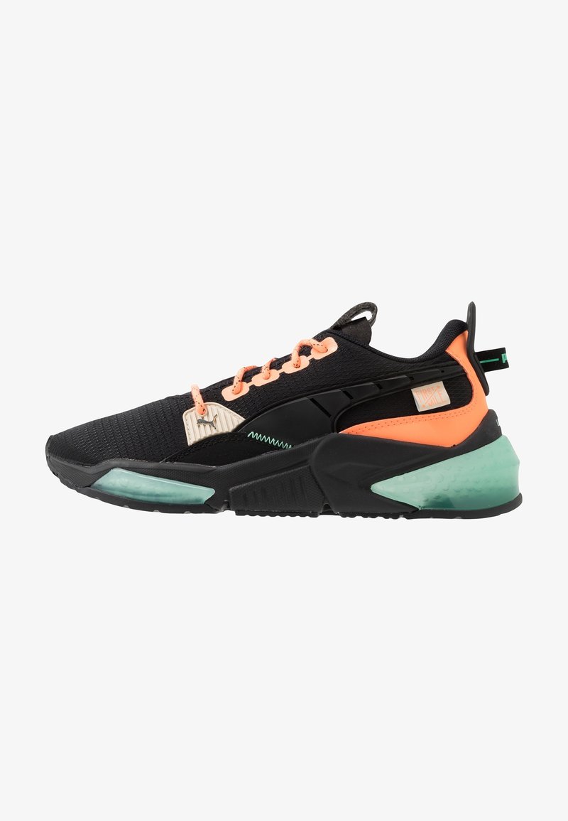 Baskets de sport noires et orange fluo avec des accents vert menthe, semelle texturée et lacets pêche, présentées en profil latéral.
