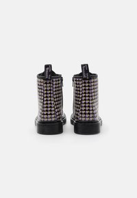 Černé kotníkové boty se vzorem fialových a žlutých srdíček, s bočními zipy a poutky, na texturované gumové podrážce.