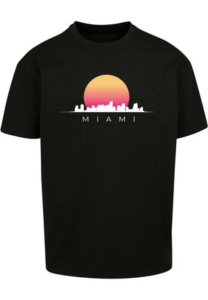 T-shirt in cotone nero con una grafica di un tramonto in sfumature di giallo e rosa sopra il profilo bianco dello skyline di Miami.