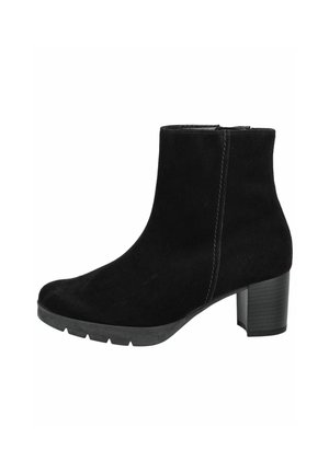 Bottines en suède noir avec un talon effilé, des détails de couture subtils et une semelle en caoutchouc texturé, arborant un design épuré et minimaliste.