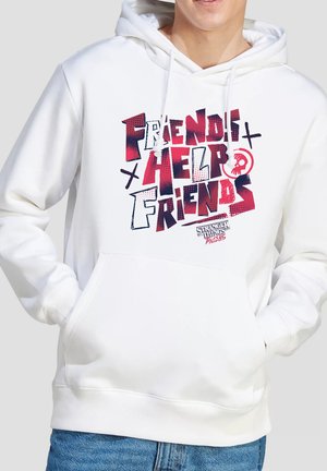 Person trägt einen weißen Hoodie mit rotem und schwarzem Text "Friends 4 Help Friends" und kleinem Totenkopf-Grafik auf der Fronttasche.