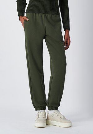 Pantaloni sportivi verdi realizzati in un tessuto misto cotone, con una vita elasticizzata, tasche laterali e gambe affusolate con polsini a costine.