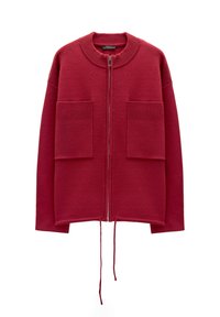 Czerwony sweter-kurtka z okrągłym dekoltem, przednim zamkiem błyskawicznym, dwoma dużymi kieszeniami z przodu, akcentami w prążki oraz sznurkiem w dolnej części.