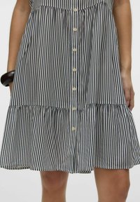 Sukienka w paski z poziomymi liniami w kolorze granatowym i kremowym, z zapięciem na guziki z przodu, rozkloszowanym dołem i lekkim materiałem. Elastyczna talia dla wygody.