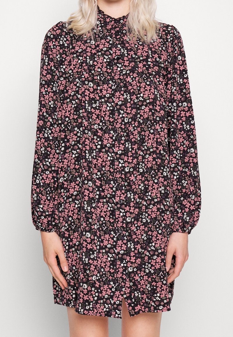 Schwarzes Blumenkleid mit langen Ärmeln, das mit rosa und weißen Blumen verziert ist, einem plissierten Design und einer Knopfleiste an der Vorderseite sowie einem Schlitz am Saum.