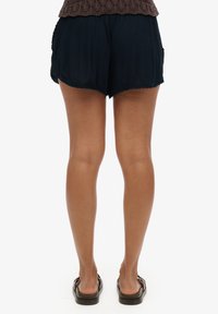 Shorts légers de couleur bleu marine, en tissu texturé, avec un ourlet festonné, dotés de poches latérales et d'une taille élastique.